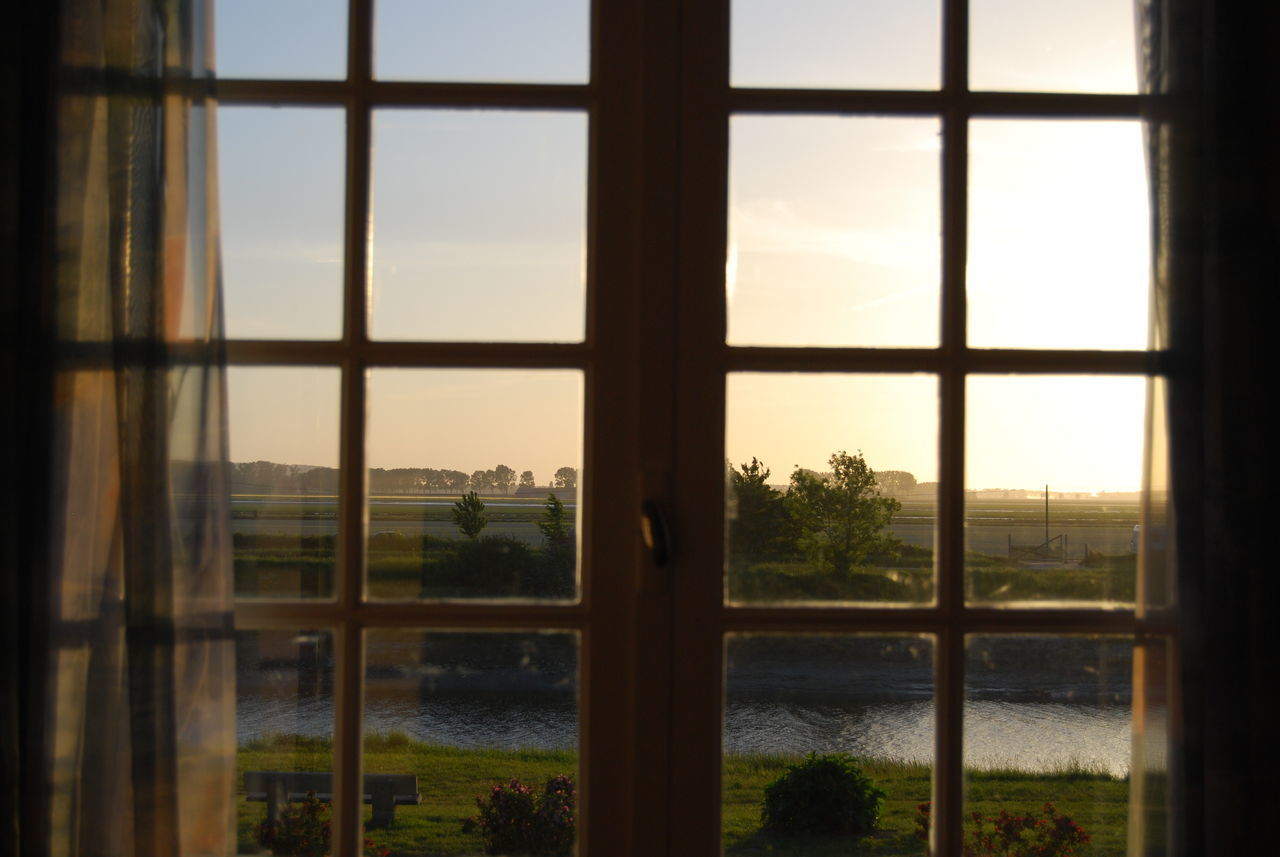 SCENIC VIEW OF LAKE SEEN THROUGH WINDOW