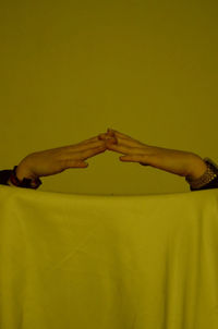 Cropped image of people against yellow background