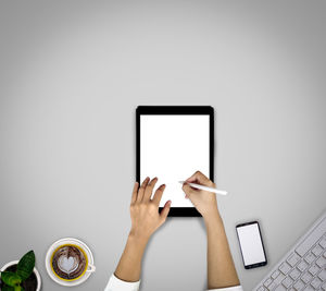 Midsection of woman using smart phone on table