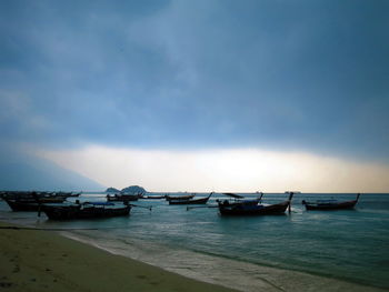 Boats moored in sea against sky