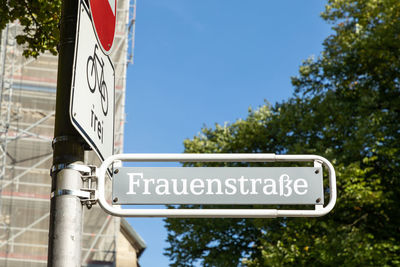 Low angle view of road sign against trees