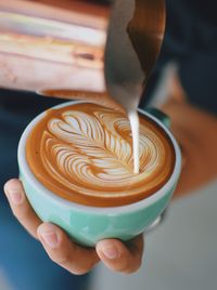 Close-up of hand holding coffee cup