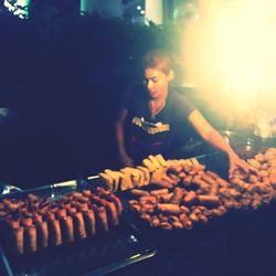 Man preparing food on barbecue grill at night