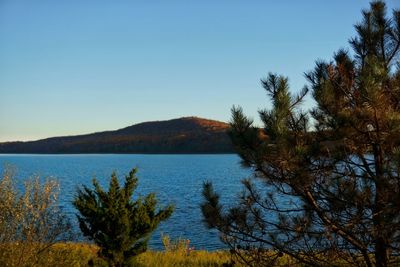 Scenic view of lake against clear blue sky