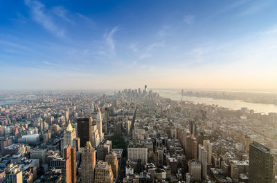 Aerial view of buildings against blue sky on sunny day