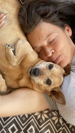 Portrait of woman with dog relaxing on bed