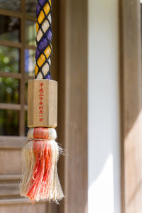 Close-up of decorations hanging on wood against building