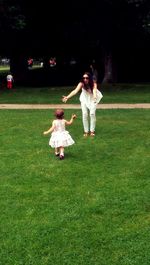 Full length of girl playing on grassy field