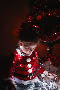 Girl sitting with illuminated string light
