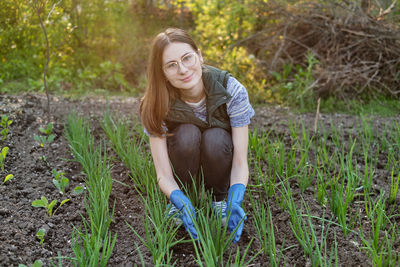 Woman works on the ground growing organic plants, fruits and vegetable