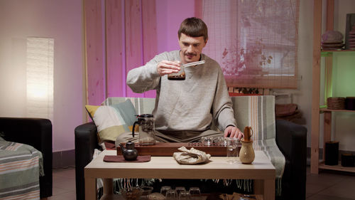 Man pouring coffee in cup at home