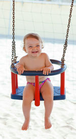 Portrait of cute baby girl sitting on swing