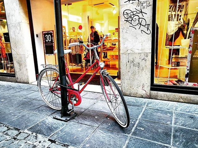 building exterior, architecture, built structure, street, graffiti, bicycle, sidewalk, cobblestone, city, transportation, land vehicle, multi colored, art and craft, mode of transport, building, art, wall - building feature, men, paving stone