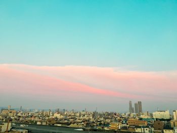 Buildings in city against sky during sunset