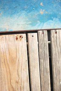 Close-up of wooden fence against blue sky