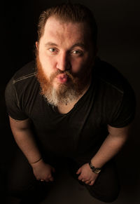 Portrait of young man against black background