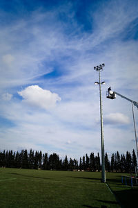 Silhouette of trees on field against cloudy sky
