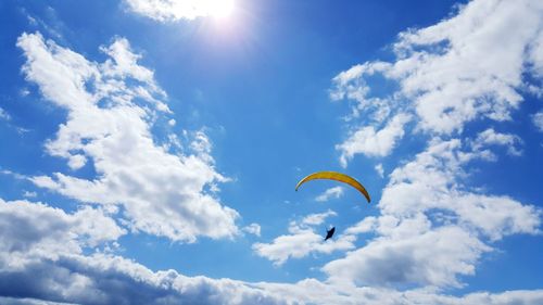 Low angle view of person parachuting against sky