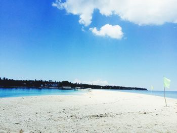 Scenic view of beach against blue sky