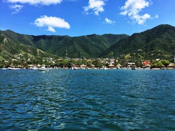 Scenic view of sea and mountains against blue sky