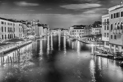 Canal amidst buildings in city against sky