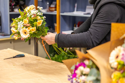 Midsection of woman holding bouquet