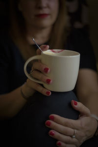 Midsection of woman holding coffee cup