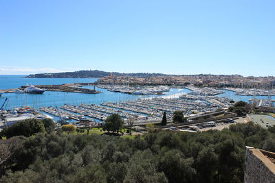 Panoramic view of sea and city against clear blue sky