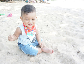 Cute boy playing on sand at beach