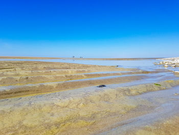Scenic view of beach against blue sky