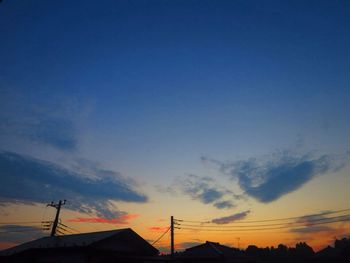 Silhouette of communications tower against sky during sunset