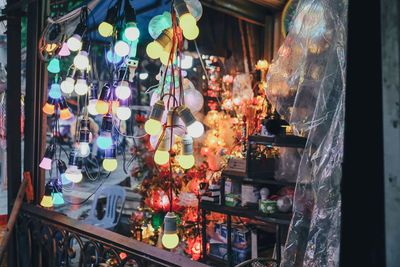 Close-up of illuminated lanterns hanging in store for sale