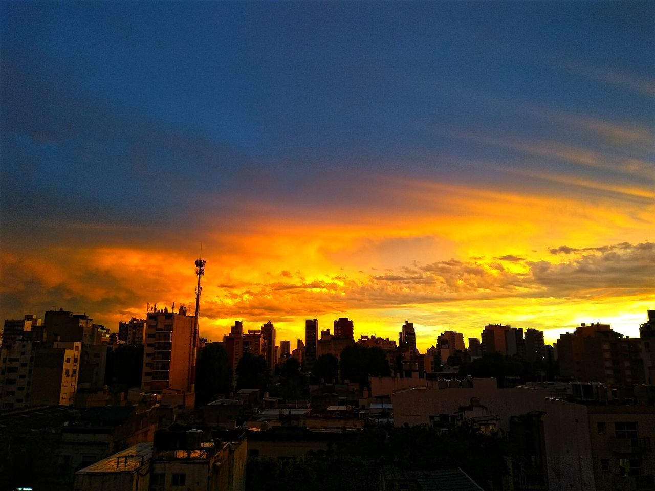 SILHOUETTE BUILDINGS AGAINST ORANGE SKY