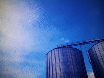 Low angle view of factory against blue sky