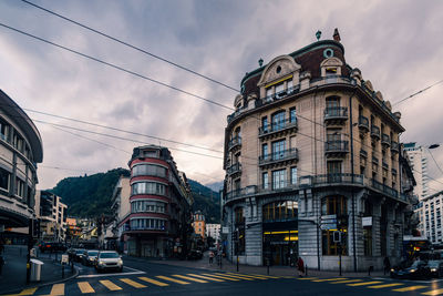 View of city street against cloudy sky