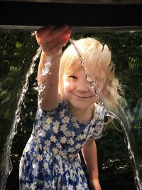 Portrait of smiling girl splashing water