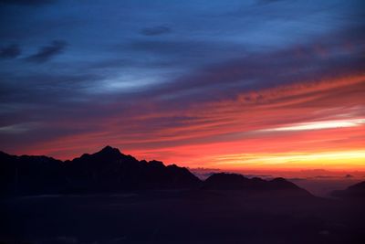 Scenic view of silhouette mountains against dramatic sky