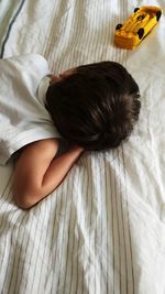 High angle view of boy sleeping on bed 