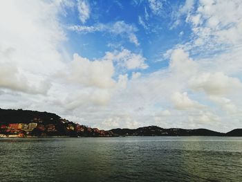 Panoramic shot of townscape by sea against sky