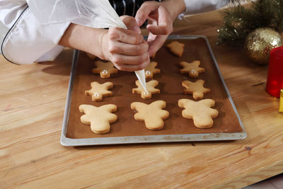 Midsection of chef preparing gingerbread cookies on table