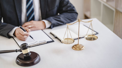 Midsection of man holding camera on table