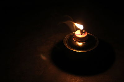 Close-up of lit candle in the dark