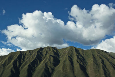 Low angle view of mountain against cloudy sky