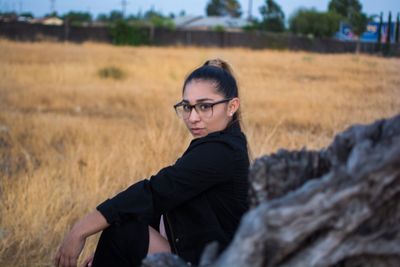 Portrait of young woman standing on field