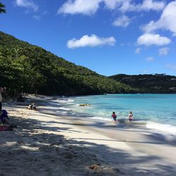 People at beach against sky