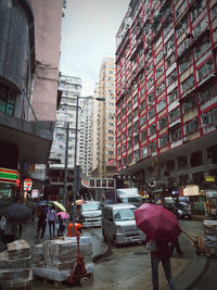 People on wet street in city during rainy season