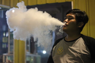 Portrait of young man smoking outdoors