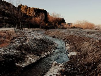 Scenic view of waterfall against clear sky during winter