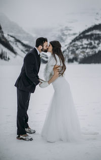 Newlywed couple just married share kiss on frozen lake louise canada