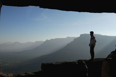 Man standing on rock looking at idyllic mountains